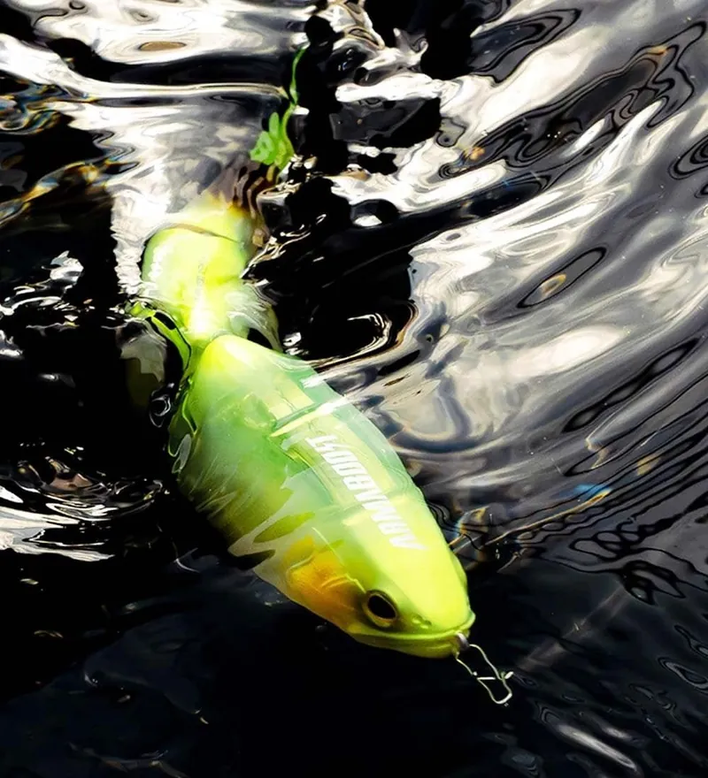 Señuelo articulado verde fluorescente nadando bajo la superficie